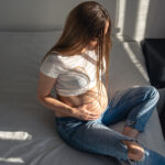 Pregnant woman on a bed in a room on a sunny morning, the concept of health and expectation of a child.